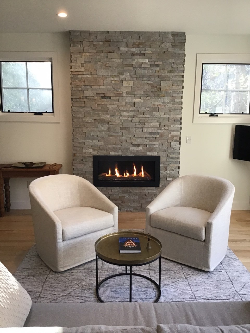 Norstone Sierra XLX Silver Grey Stacked Stone Panels cladding a floor to ceiling fireplace in a modern designed living room